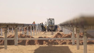 Group of men working on a site of solar energy