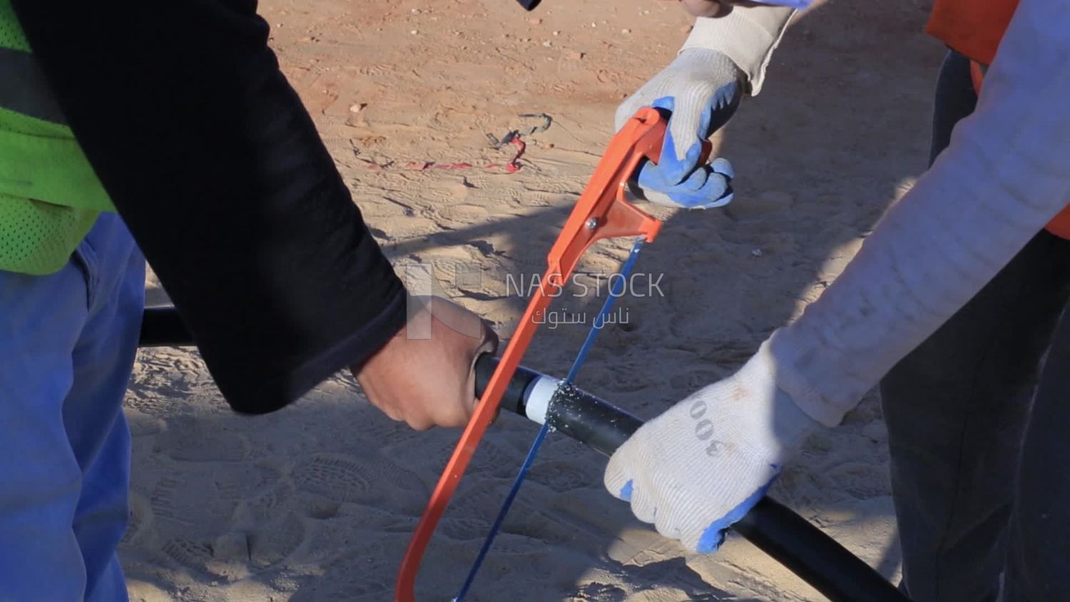 Two men are cutting a pipe in a site of solar energy