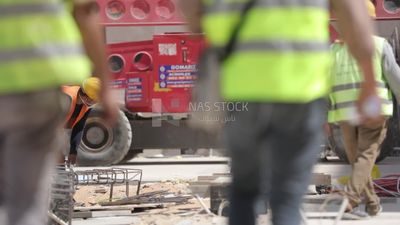 Two workers working in different things on a building site