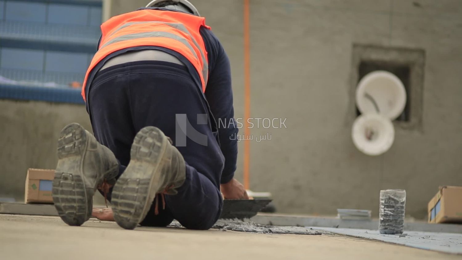 Worker puts cement on the floor at a building site