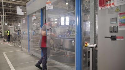 Man opens the door of a machine in a factory, factory equipment