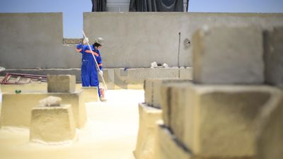 Worker applies material insulating the building using the paint roller, Isolation work