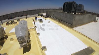 Workers apply insulation material to the building using a paint roller, Isolation work