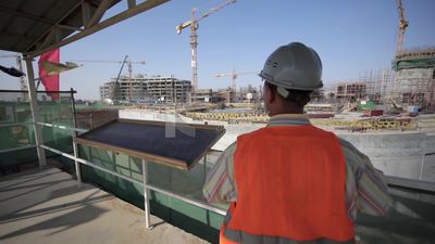 Engineer standing away looks at a construction site