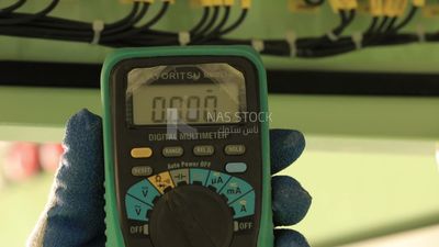 Man measures electricity with a voltage meter