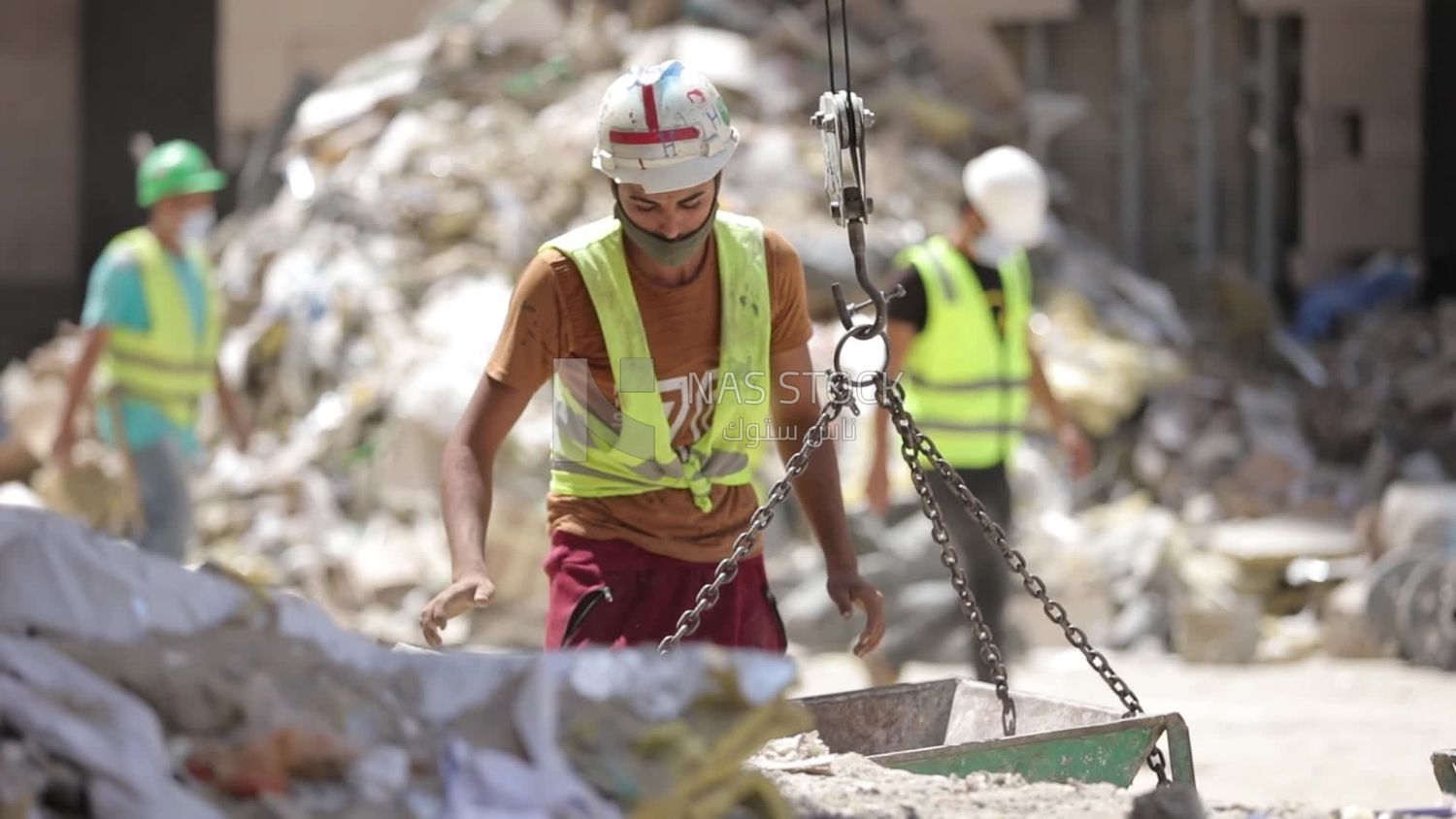 Worker puts bricks on a cart at a building site
