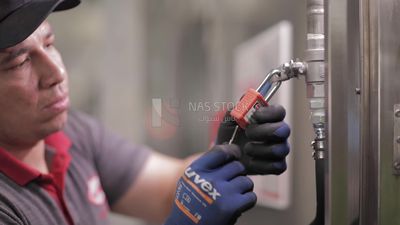 Worker locks the door of a machine in a factory, factory equipment, machine