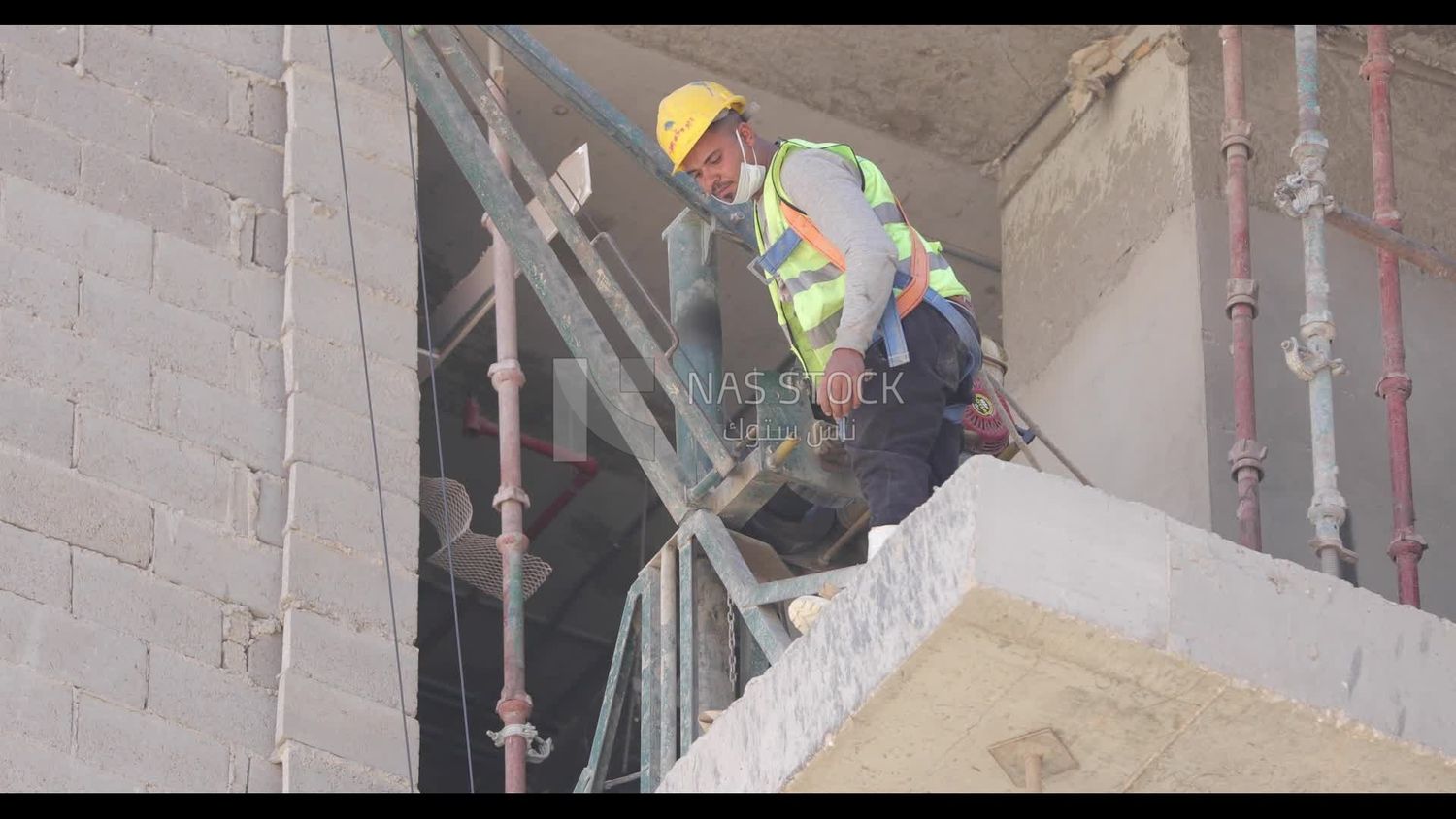Worker standing beside a machine on a construction site