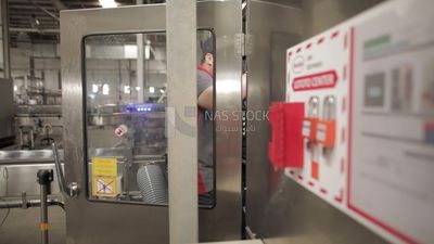 Man opens the door of a machine in a factory, factory equipment