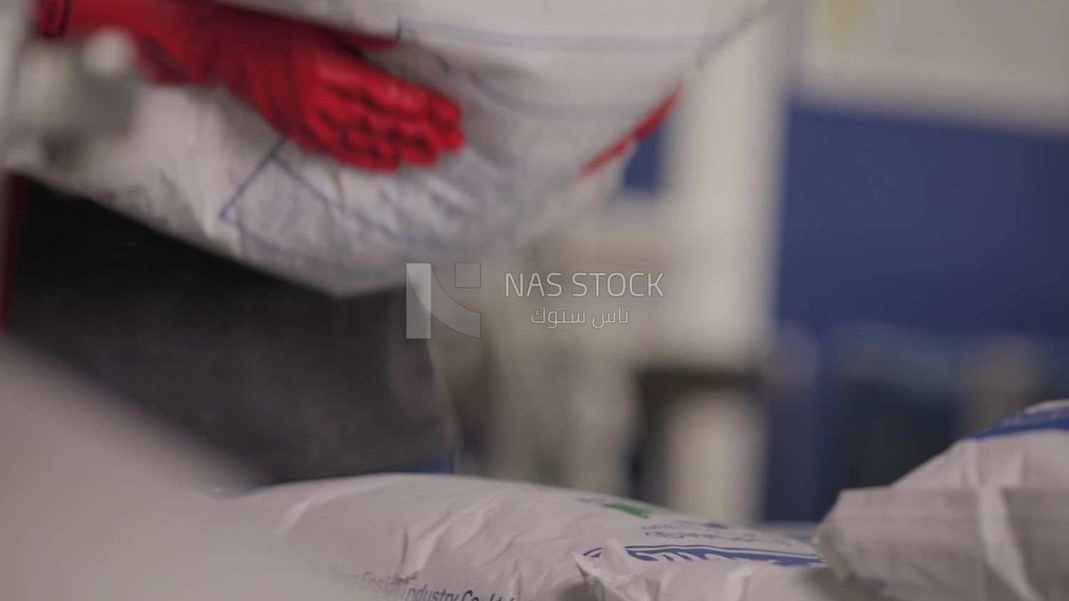 Worker carrying a woven bag in a factory, factory equipment