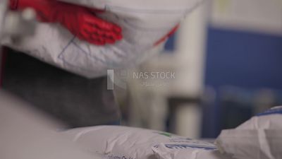 Worker carrying a woven bag in a factory, factory equipment