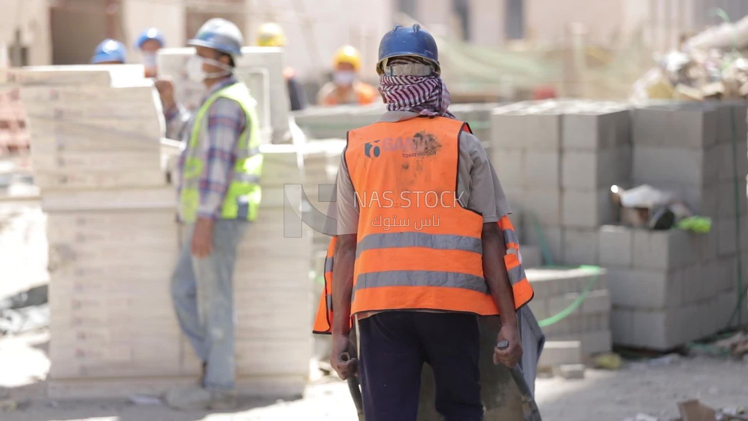 Worker pulling a cart on a building site