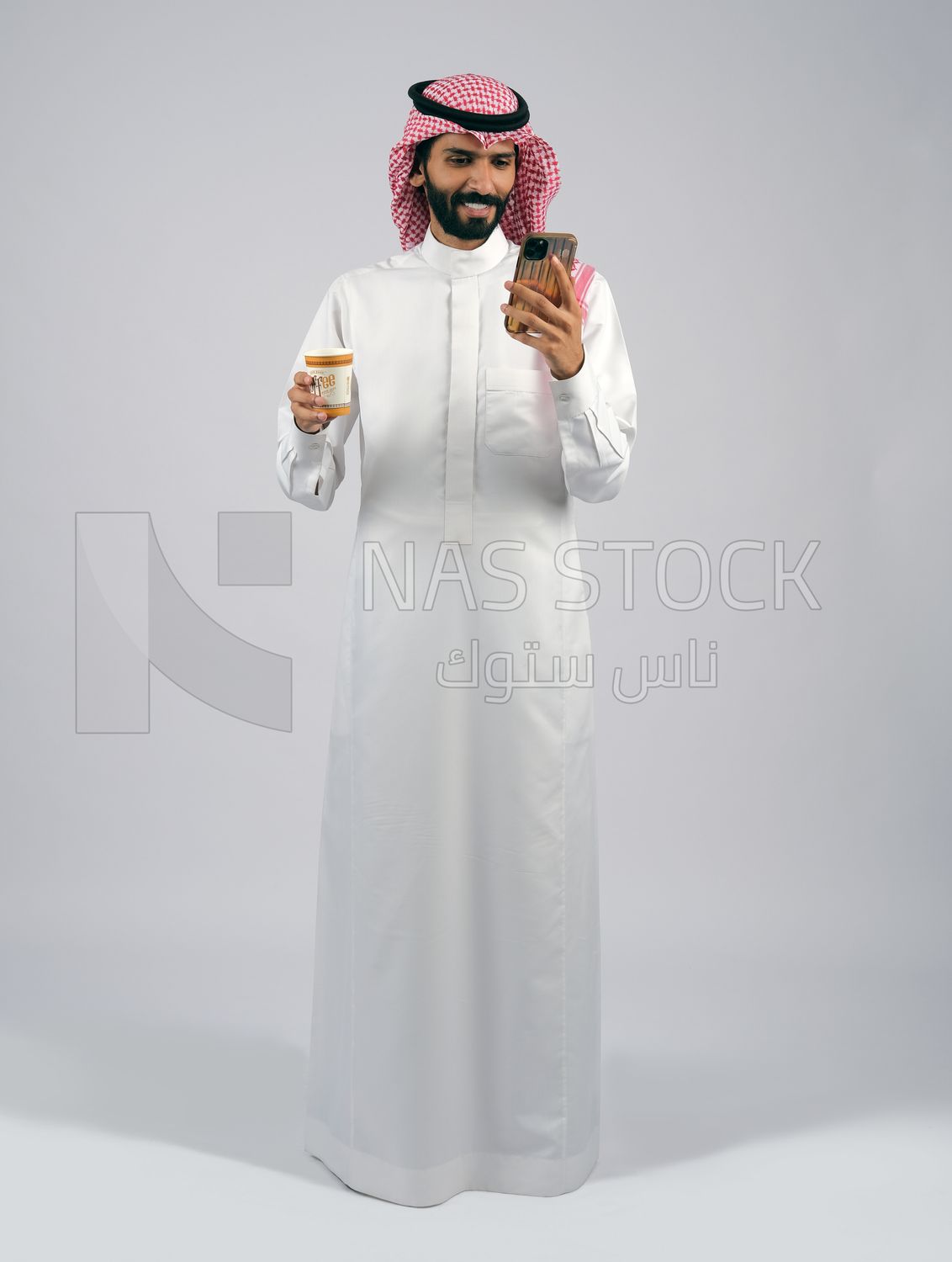 Gulf man holding a cup of coffee and mobile
