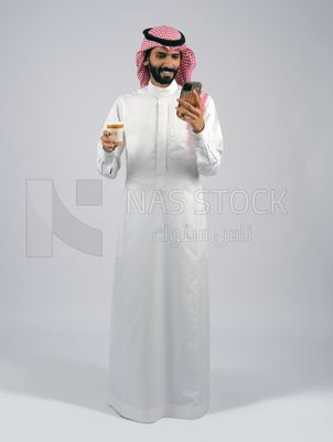 Gulf man holding a cup of coffee and mobile