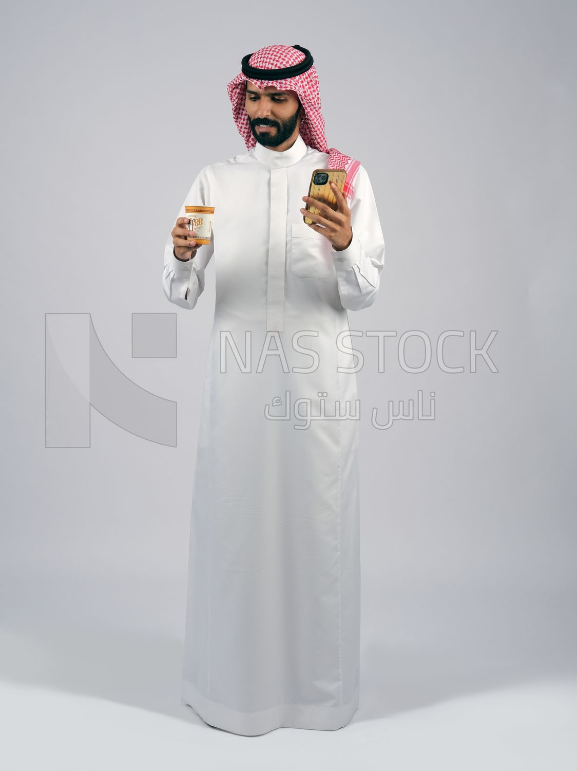 Gulf man holding a cup of coffee and mobile