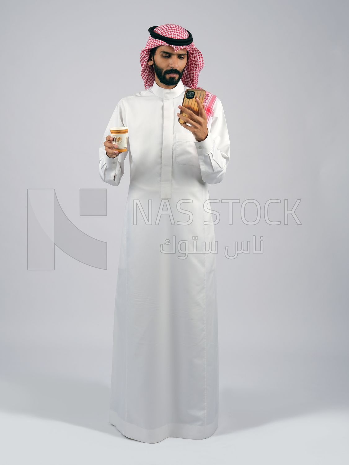 Gulf man holding a cup of coffee and mobile