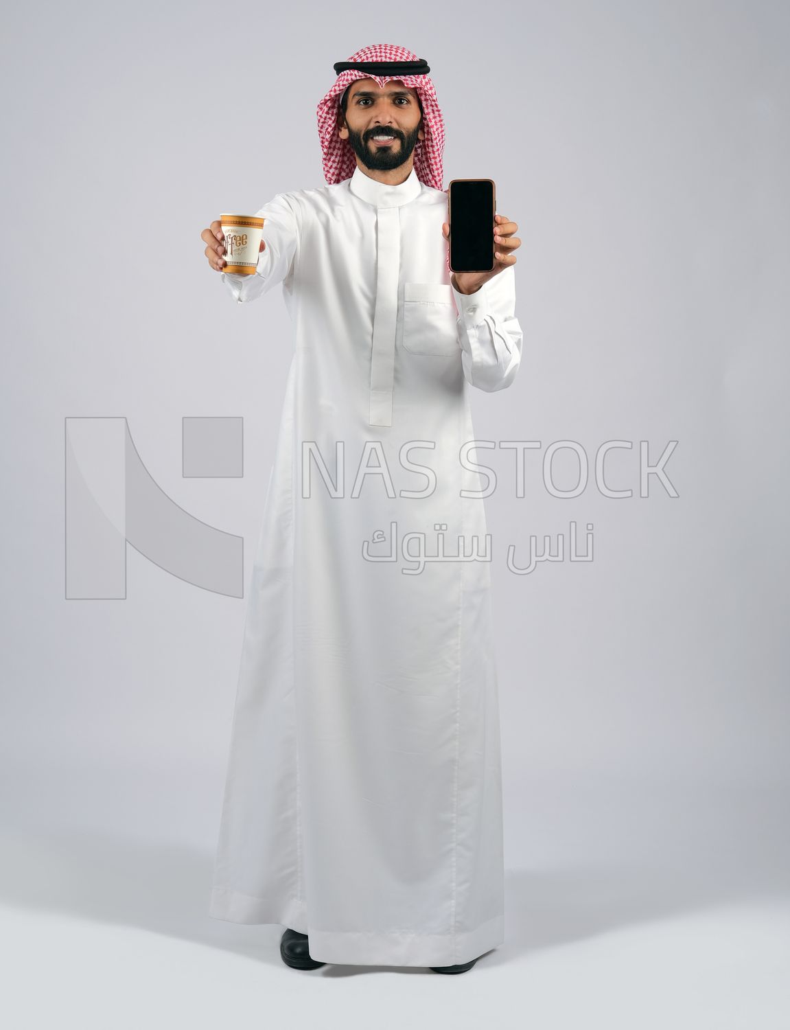 Gulf man holding a cup of coffee and mobile