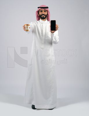 Gulf man holding a cup of coffee and mobile