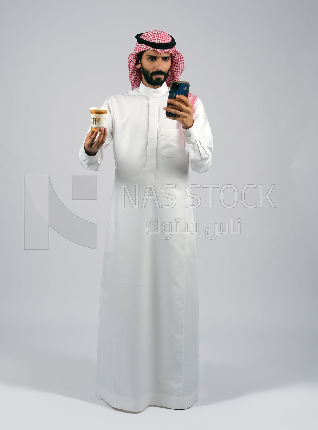 Gulf man holding a cup of coffee and mobile