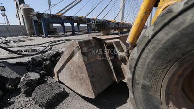 Tractor lifts a stone from the ground on a building site, engineering tools and equipment