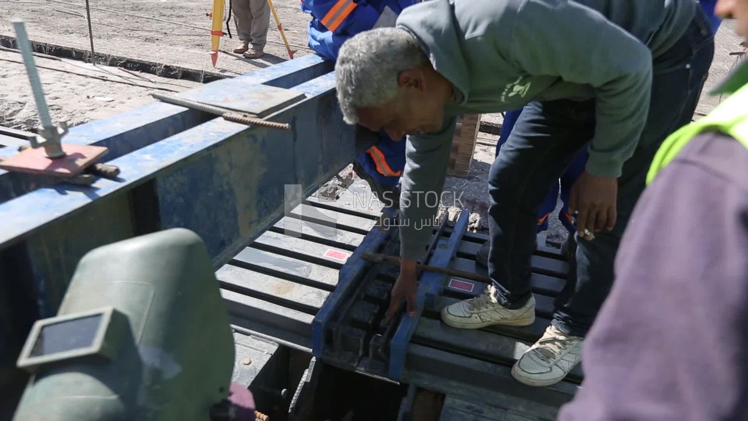 Group of engineers trying to put a part of a bridge to complete it, work, construction, engineering tools and equipment
