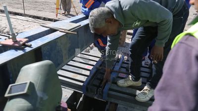 Group of engineers trying to put a part of a bridge to complete it, work, construction, engineering tools and equipment