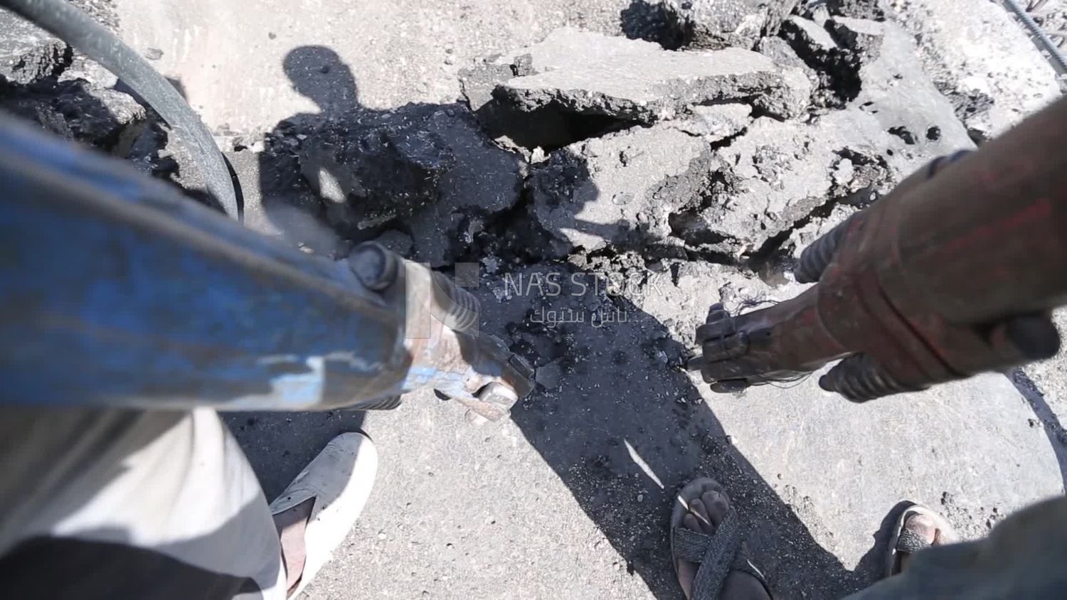 Worker using a drill to make a hole in the ground