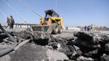 Tractor lifts a stone from the ground on a building site, engineering tools and equipment