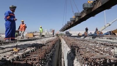 Group of engineers trying to put a part of a bridge to complete it, work, construction, engineering tools and equipment