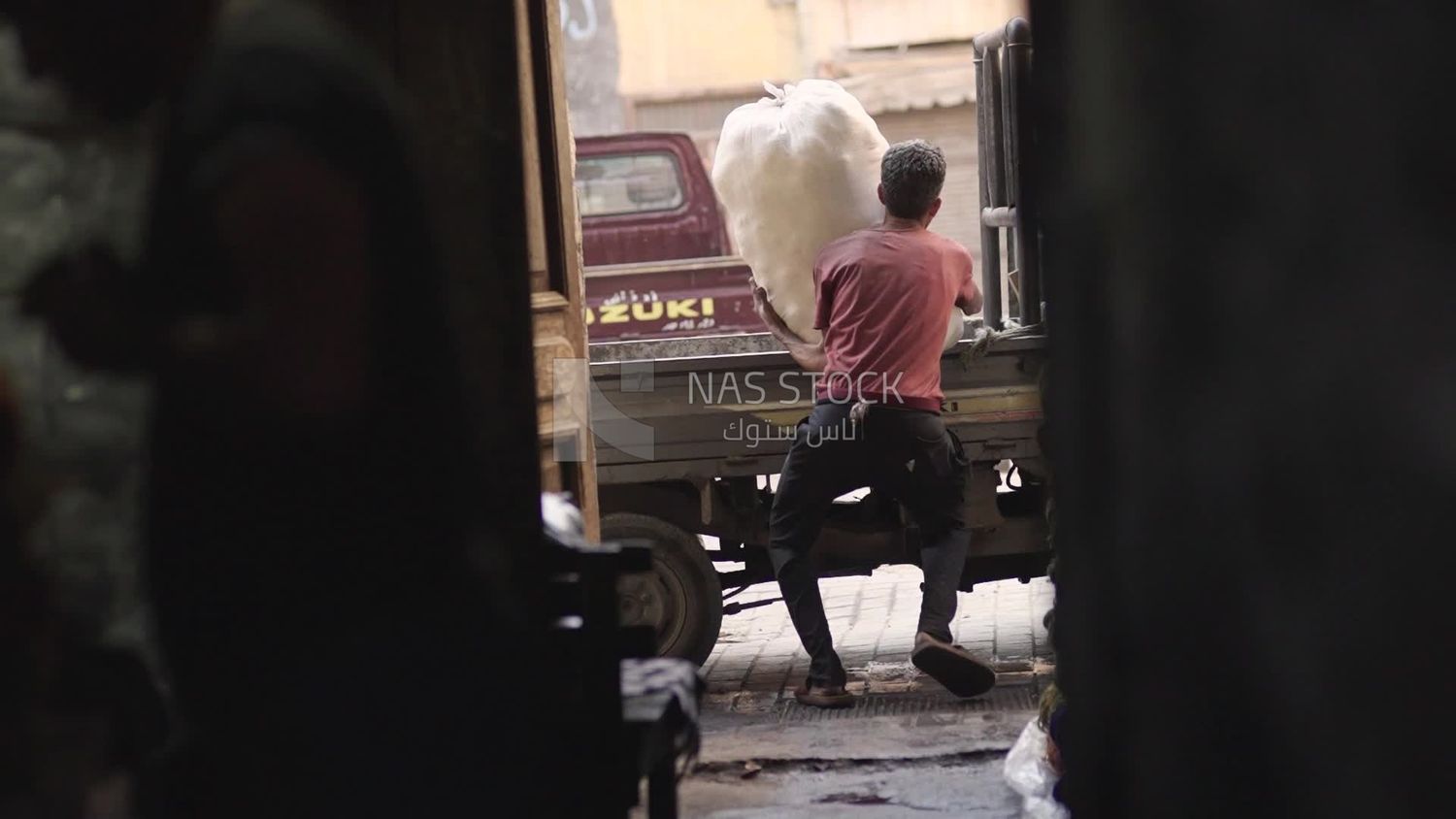 Worker tries to carry a large sack