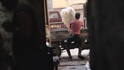 Worker tries to carry a large sack