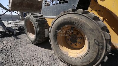 Tractor lifts a stone from the ground on a building site, engineering tools and equipment