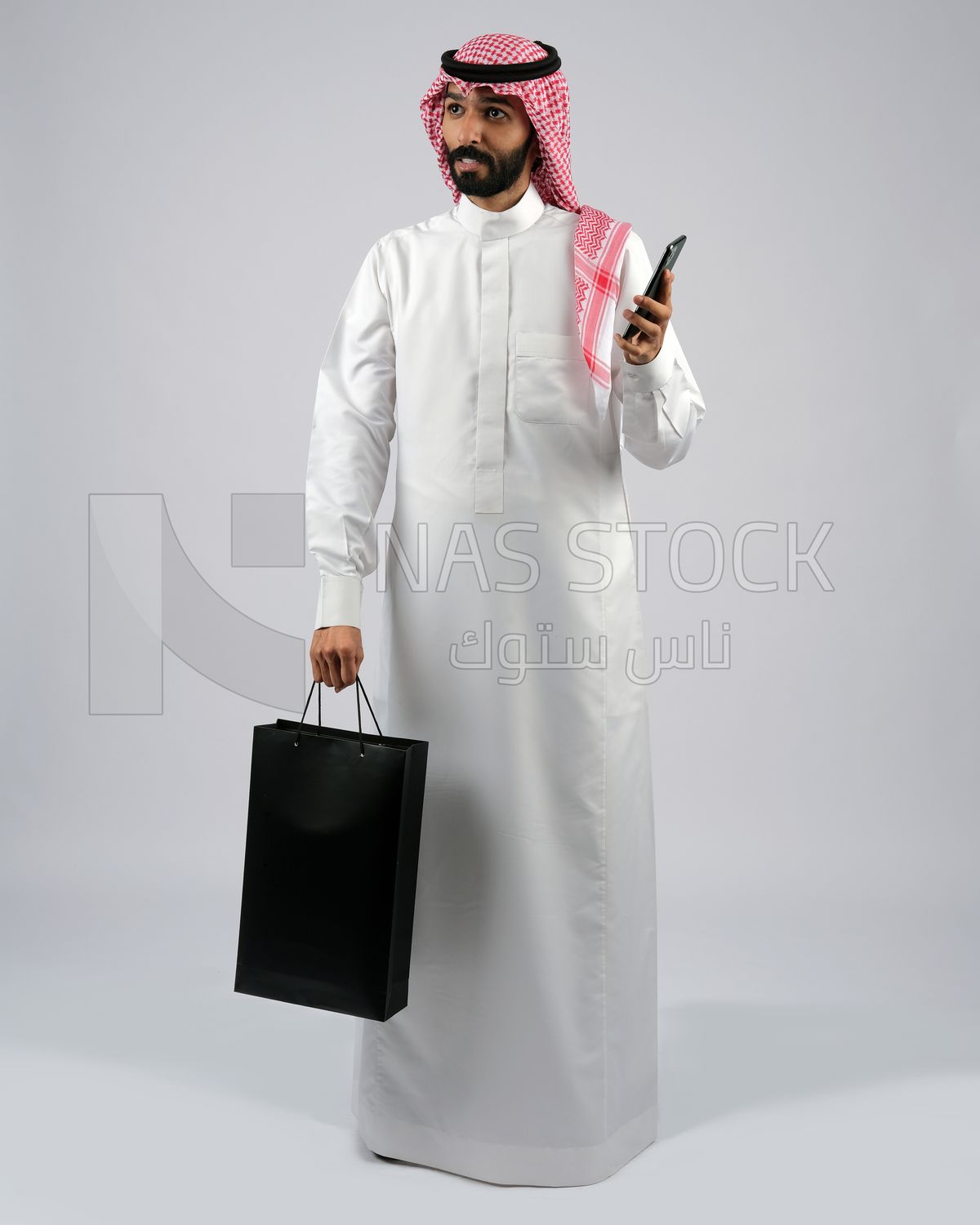 Gulf man carrying black shopping bag