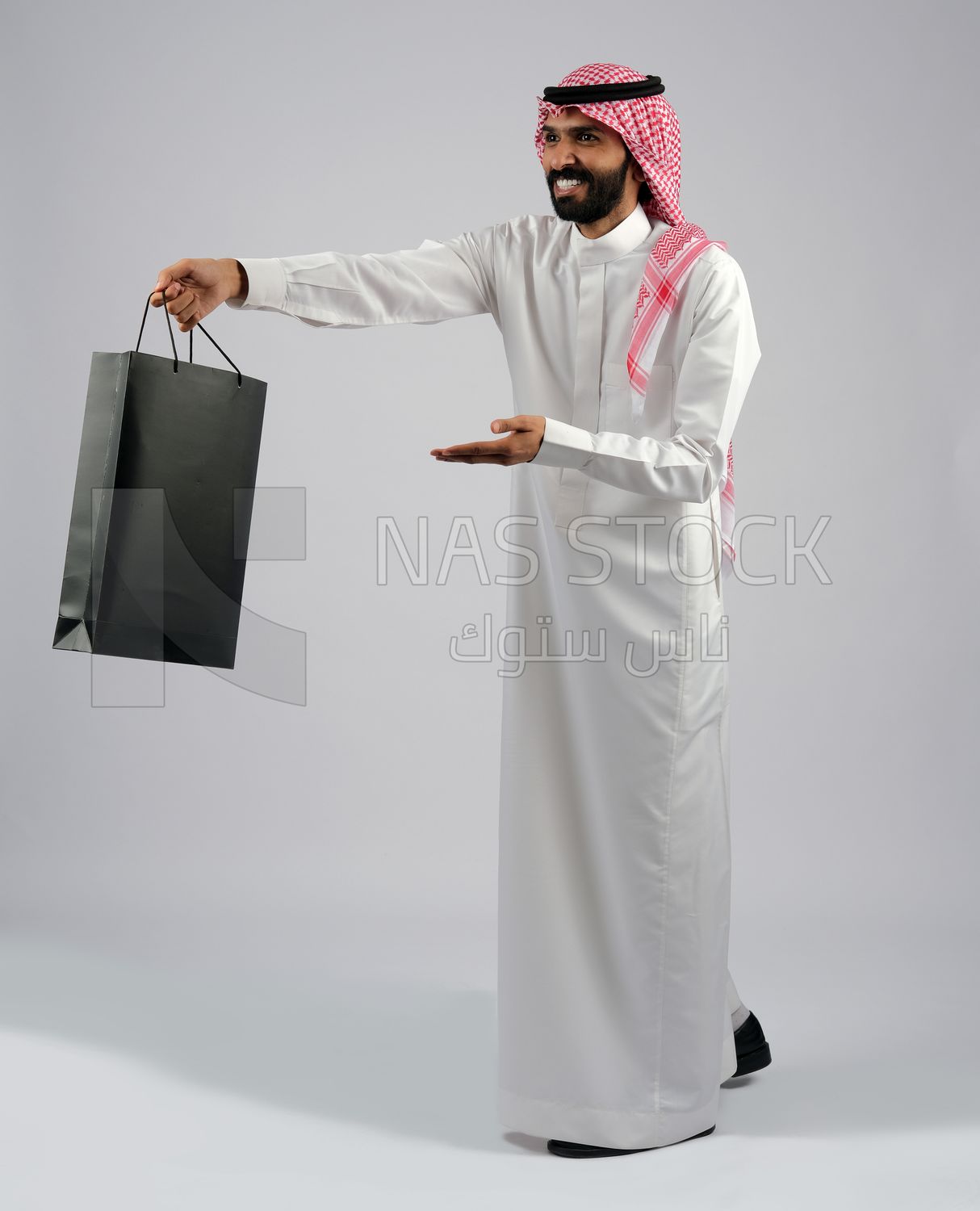 Gulf man carrying black shopping bag