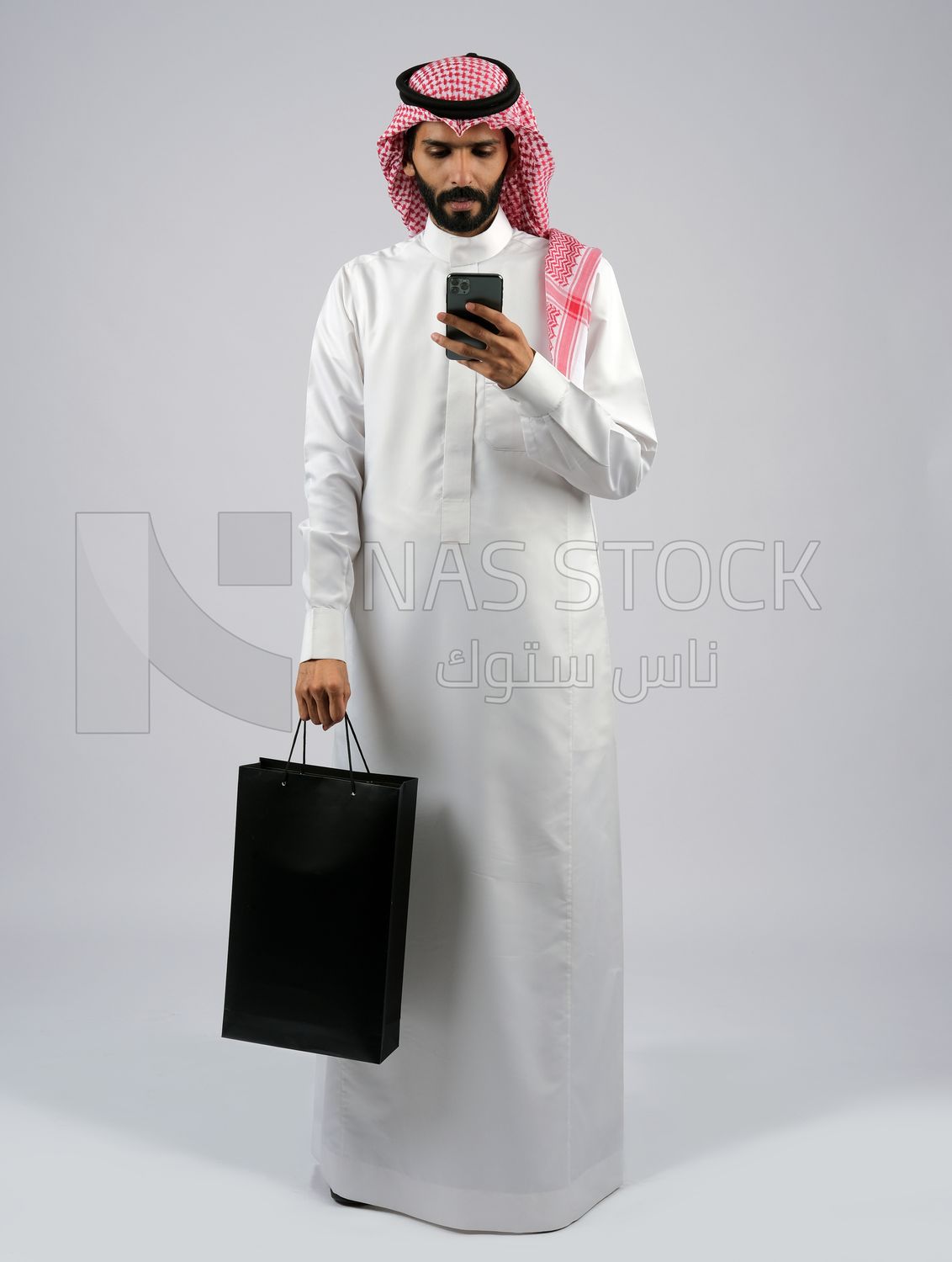 Gulf man carrying black shopping bag