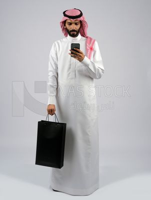 رجل خليجي يحمل كيس تسوق اسود