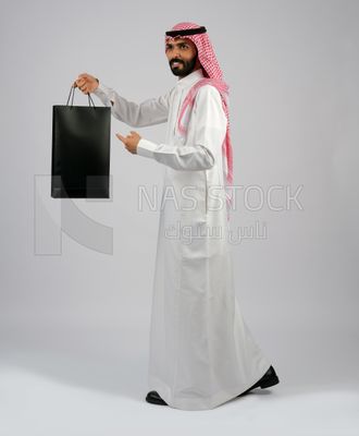 Gulf man carrying black shopping bag