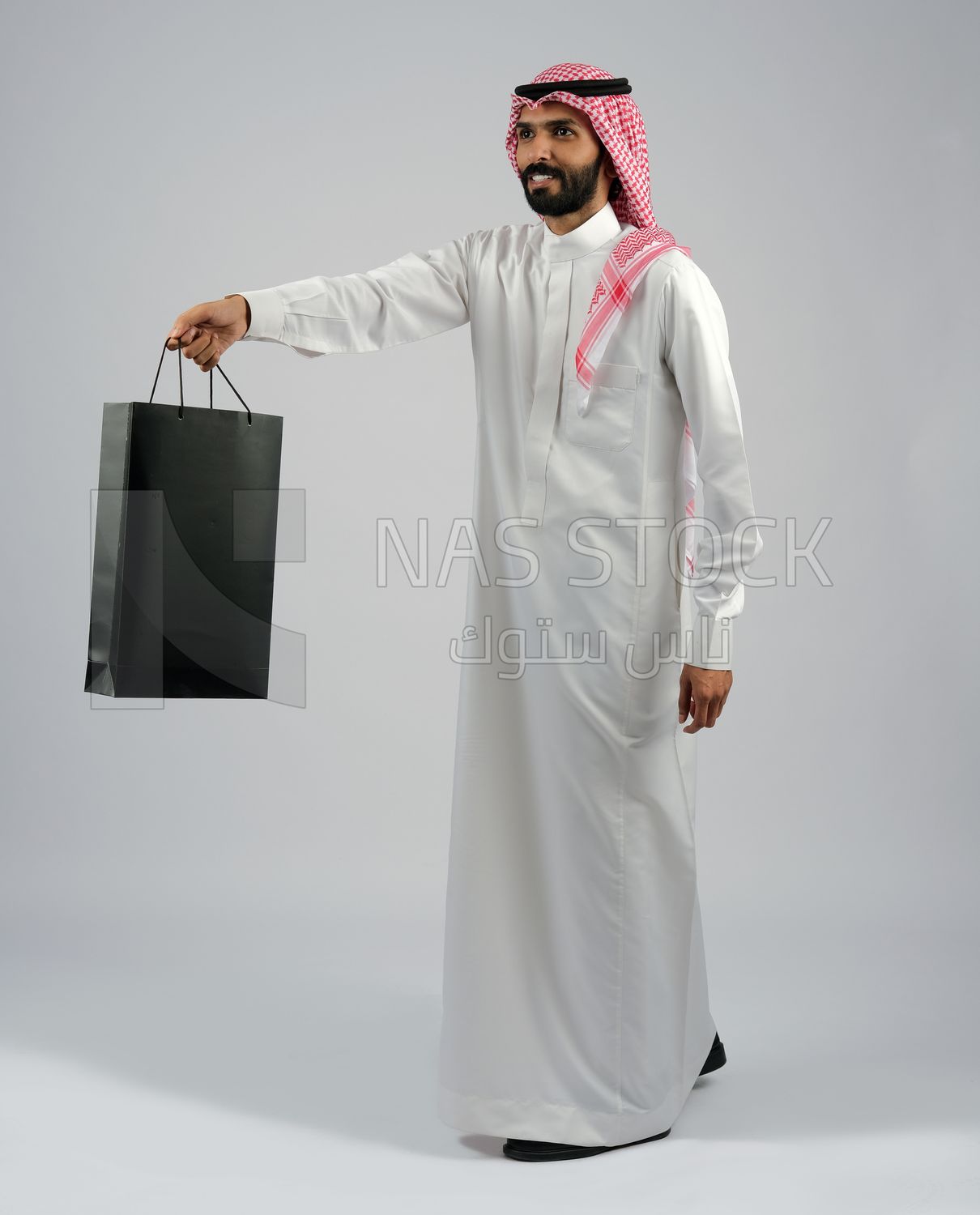 Gulf man carrying black shopping bag