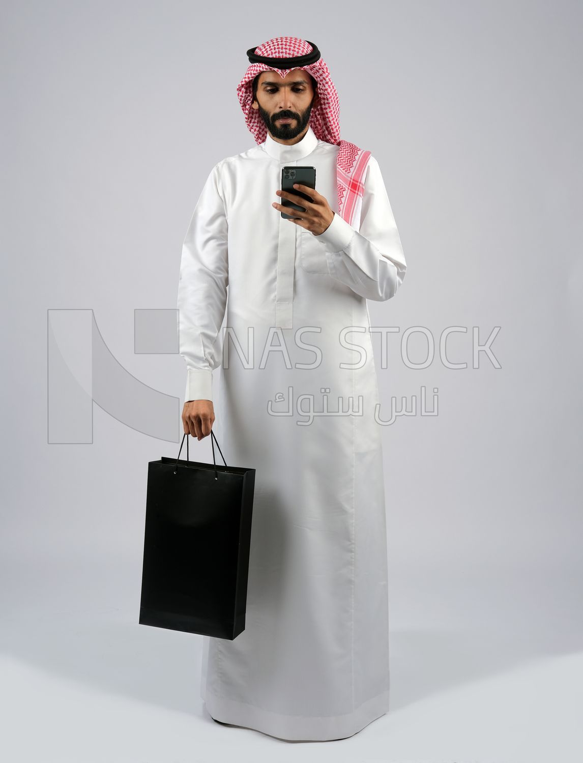 Gulf man carrying black shopping bag