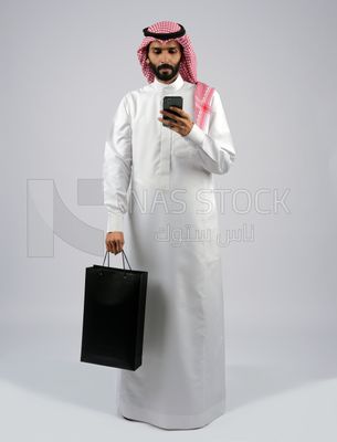 Gulf man carrying black shopping bag
