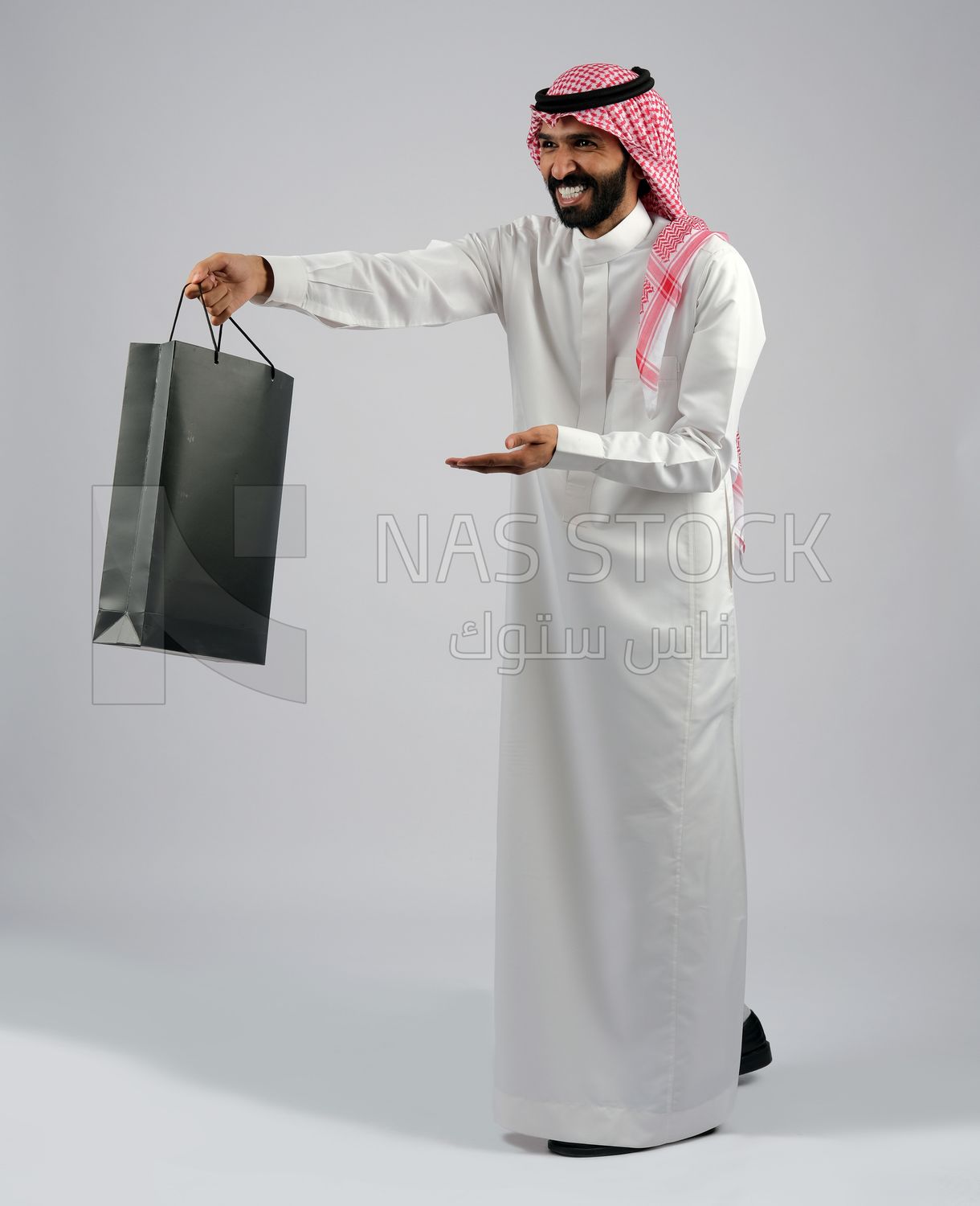 Gulf man carrying black shopping bag
