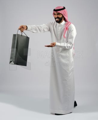 Gulf man carrying black shopping bag