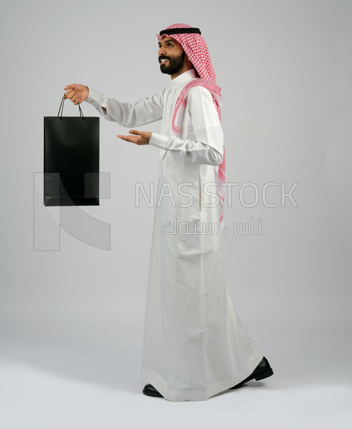 Gulf man carrying black shopping bag
