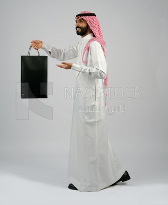 Gulf man carrying black shopping bag