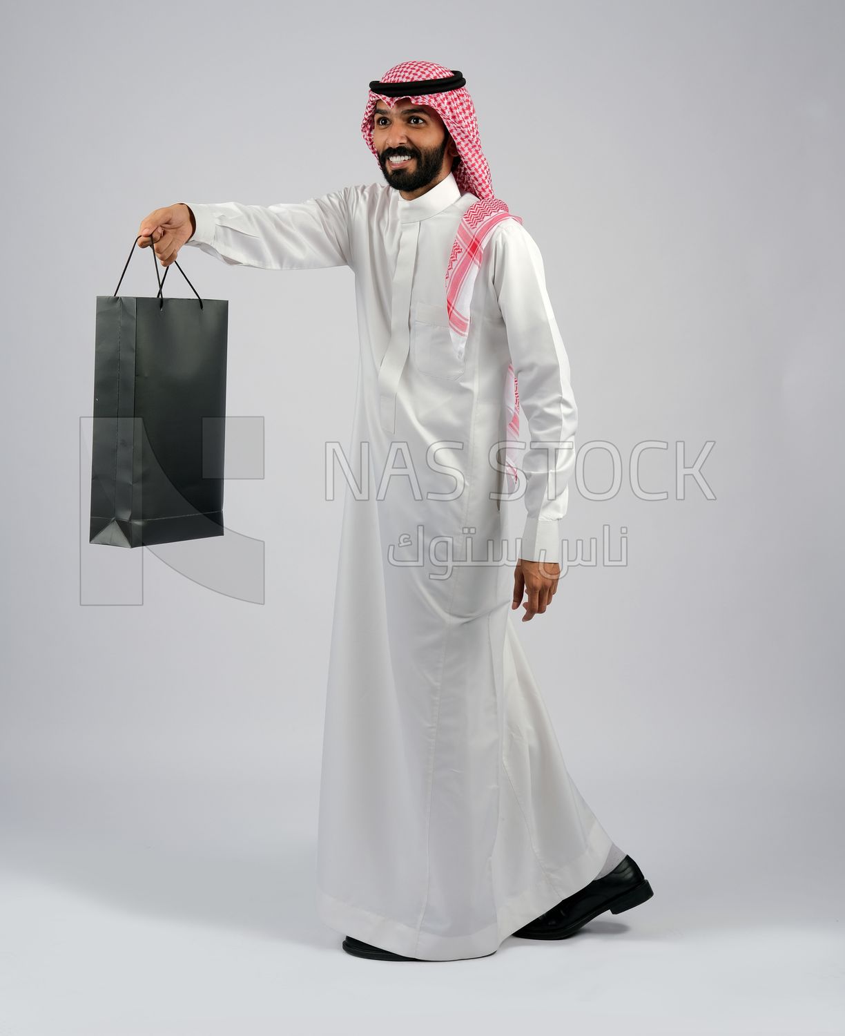 Gulf man carrying black shopping bag