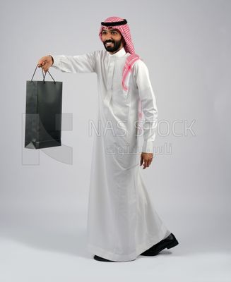 Gulf man carrying black shopping bag