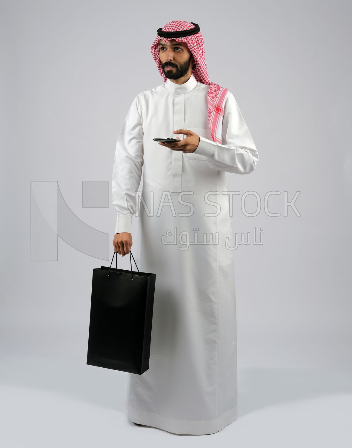 رجل خليجي يحمل كيس تسوق اسود