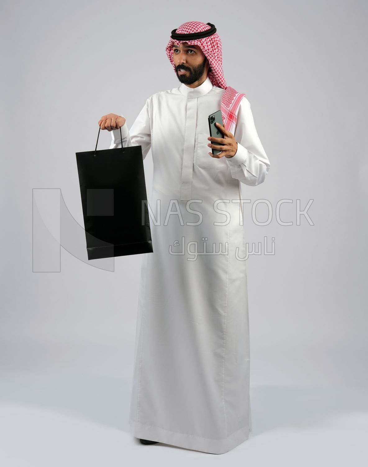 Gulf man carrying black shopping bag