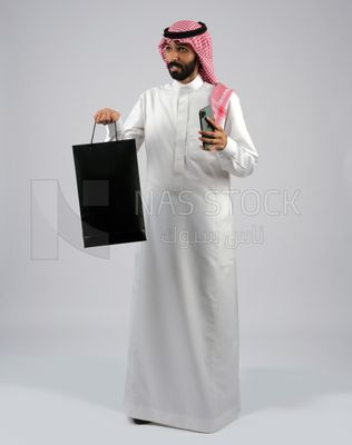 Gulf man carrying black shopping bag