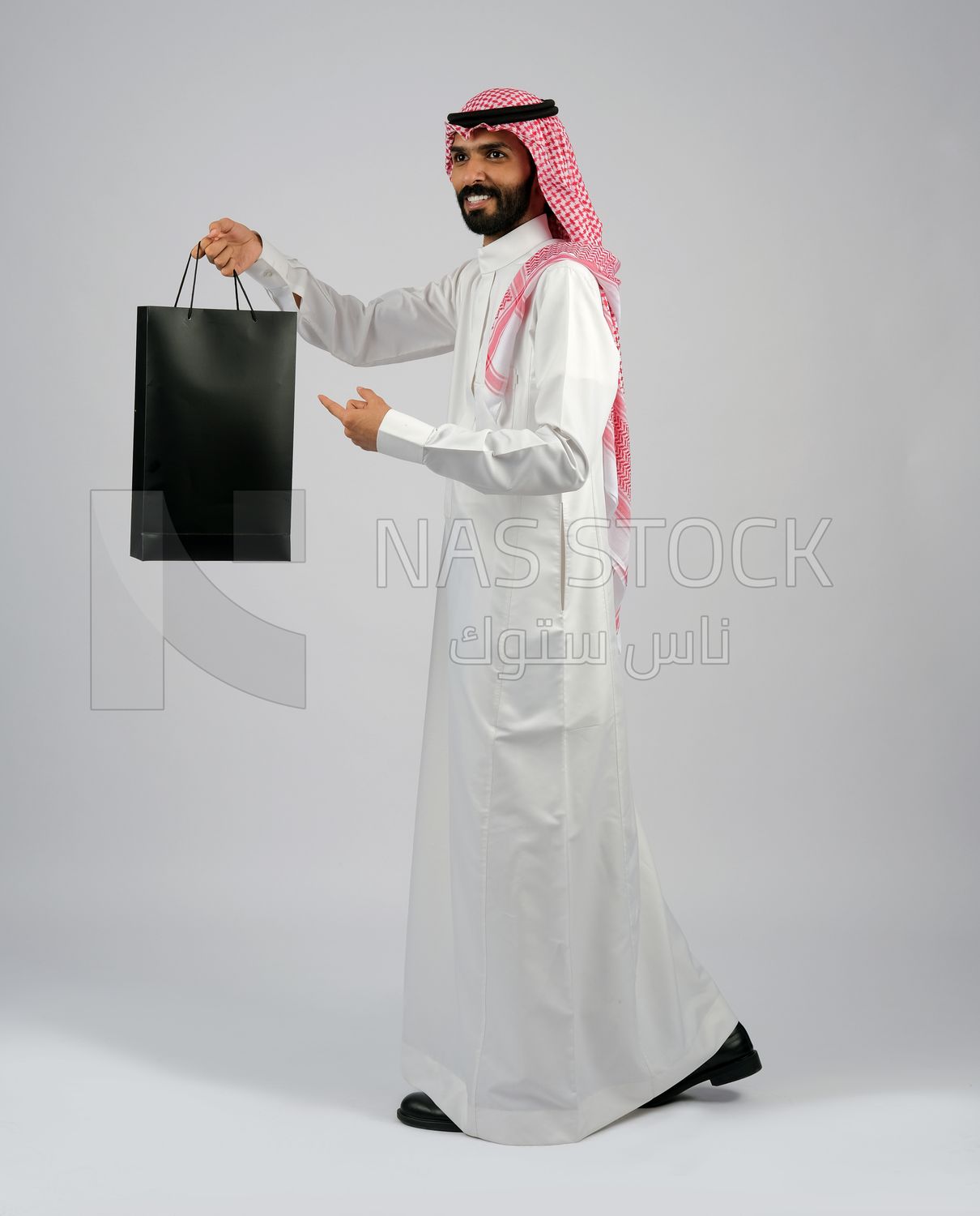 Gulf man carrying black shopping bag